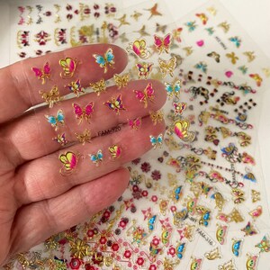 May include: A sheet of clear nail stickers with gold and colorful butterfly designs. The sheet is labeled "FAM-320".
