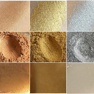 K&ouml;nnte beinhalten: Neun Lidschatten-Swatches in verschiedenen Farbt&ouml;nen. Die Farben reichen von hellem Gold und Silber bis hin zu tieferen Bronze- und Kupfert&ouml;nen. Die Texturen variieren von fein gemahlenen Puder bis zu glatten, cremigen Finishes mit sichtbarem Schimmer.
