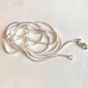 Op de afbeelding: Een zilveren slangenketting met een karabijn sluiting.