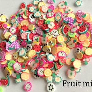 Peut inclure: Assortiment de charmes en pâte polymère en forme de fruits colorés, notamment des fraises, des tranches de pastèque, des citrons, des limes et des kiwis. Les charmes sont parfaits pour ajouter une touche de fantaisie à l'artisanat et aux bijoux.