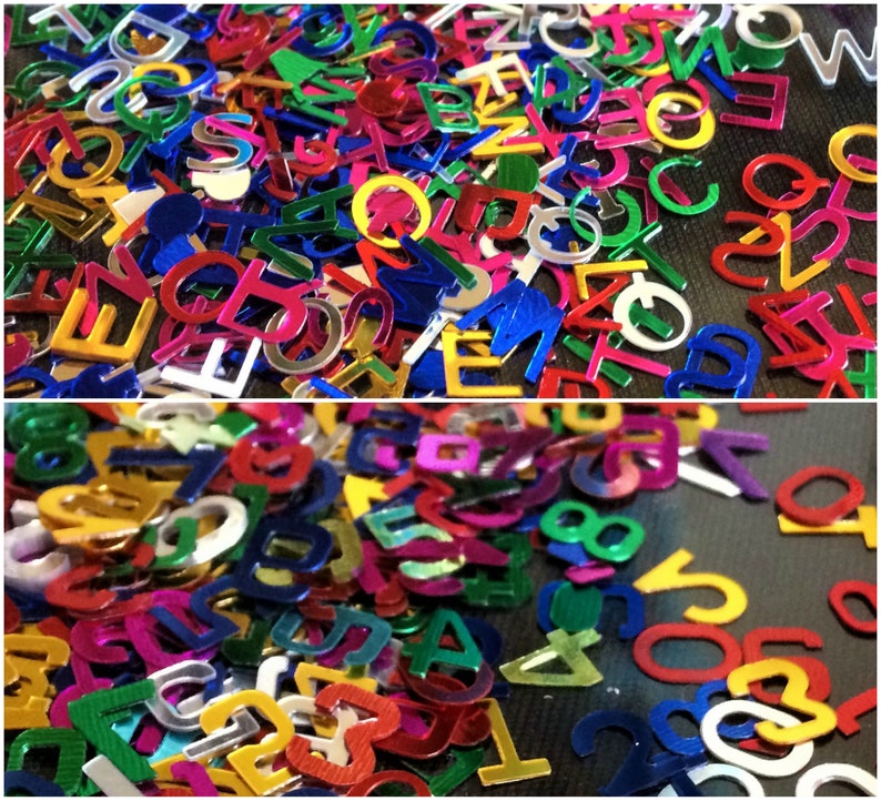 Puede incluir: Una imagen de primer plano de una gran cantidad de letras y n&uacute;meros met&aacute;licos de colores. Las formas est&aacute;n dispersas sobre una superficie oscura. Las letras y los n&uacute;meros son de varios colores, incluyendo rojo, azul, verde, amarillo y plateado.