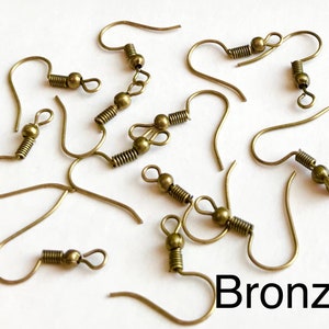 May include: A close-up of ten bronze earring hooks with spring closures. The hooks are scattered on a white surface. The word "Bronze" is written in black letters at the bottom of the image.
