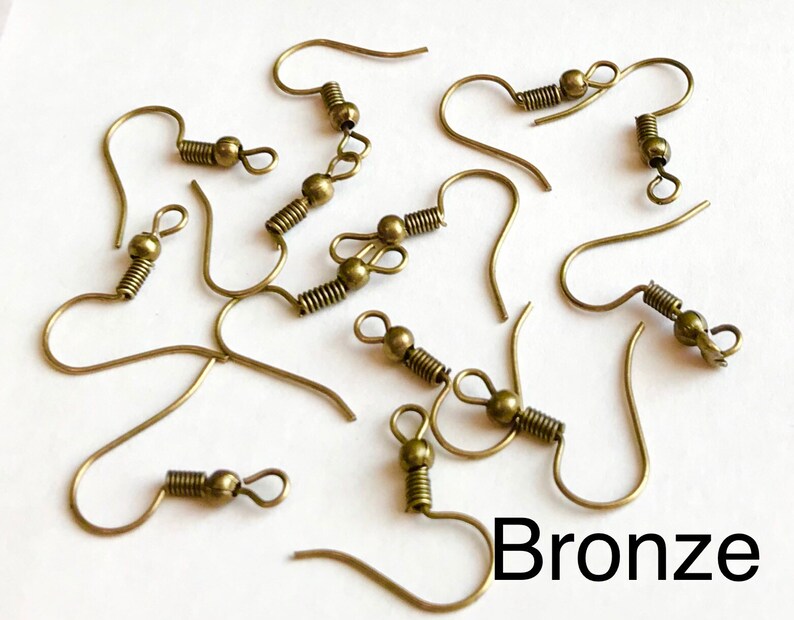 May include: A close-up of ten bronze earring hooks with spring closures. The hooks are scattered on a white surface. The word "Bronze" is written in black letters at the bottom of the image.