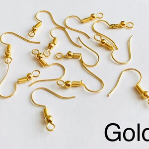 May include: A close-up of ten gold earring hooks. The hooks are made of metal and have a spring-loaded closure.