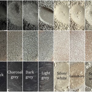May include: A collection of eight eyeshadow samples in shades of gray and white. The shades are labeled "Black", "Charcoal grey", "Dark grey", "Light grey", "Silver white", "Gainsboro", and "Snow white".