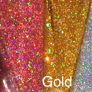 Puede incluir: Primer plano de tres colores diferentes de purpurina iridiscente: rosa, oro y plata. La purpurina dorada tiene la palabra "Oro" escrita debajo.