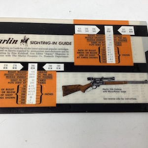 May include: A rectangular Marlin Sighting-In Guide featuring black, white, and orange sections. It displays technical ballistic data for various cartridges, including bullet weight, velocity, and energy, alongside an illustration of a Marlin 336 Carbine.