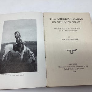 May include: A book titled "The American Indian on the New Trail: The Red Man of the United States and the Christian Gospel" by Thomas C. Moffett. The book cover features a black and white photograph of a Native American man on horseback.