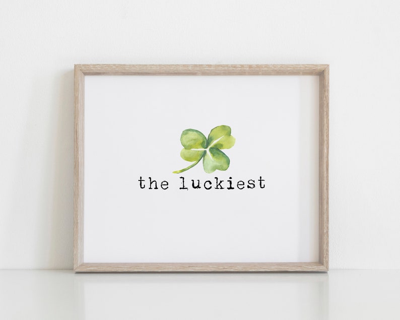 May include: A framed print with a watercolor illustration of a four-leaf clover and the text "the luckiest".