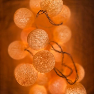 May include: A string of warm white cotton ball lights, perfect for adding a cozy and festive touch to any space.