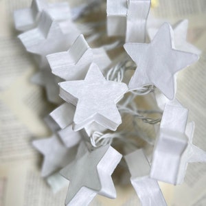 May include: A string of white star-shaped LED lights. The lights are strung together with a clear wire and are perfect for adding a touch of whimsy to any space.