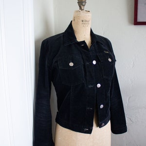May include: A black corduroy jacket with silver buttons and a label that reads "Wolf Form Co. N.Y.C." and "Model 1980".