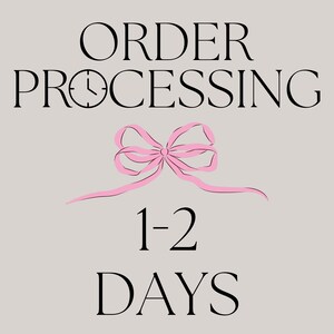 Może przedstawiać: Jasnoszary znak graficzny z czarnym napisem ORDER PROCESSING, w kt&oacute;rym ikona zegara zastępuje literę O. Poniżej wyśrodkowana jest jasnor&oacute;żowa kokarda, a pod nią znajduje się czarny napis 1-2 DAYS wyraźną, pogrubioną czcionką szeryfową.