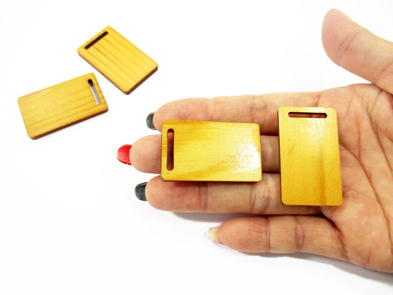 Adult palm holding handcrafted 1:12 scale miniature wooden boards, highlighting the realistic wood texture for mini collectors.