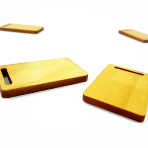 Miniature 1:12 wooden cutting board 23x38 mm close-up on white surface; thin, smooth, realistic wood texture for mini scenes.