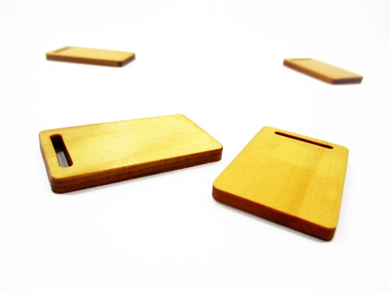 Miniature 1:12 wooden cutting board 23x38 mm close-up on white surface; thin, smooth, realistic wood texture for mini scenes.