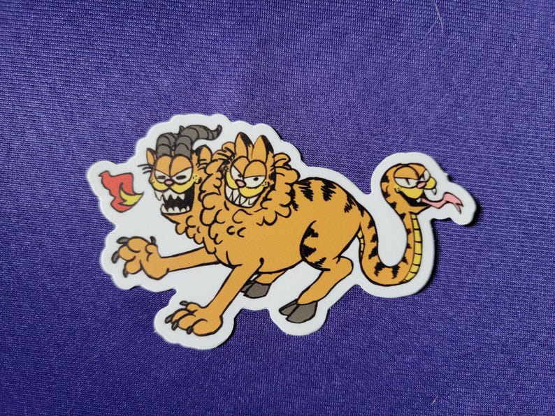 May include: A sticker featuring a mythical creature with two orange tabby cat heads and a snake tail. One head has goat horns and sharp teeth, while the other has a lion-like mane. The creature has a striped orange body, claws, and a small flame.
