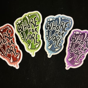 May include: Four colorful stickers with a foot-shaped design. Each sticker features the words "WHORE FOR VORE" in a bold, handwritten font. The stickers are in red, green, blue, and purple, with white outlines and a black background.