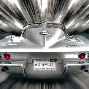 May include: Silver 1963 Corvette 'Split' with red taillights and chrome accents. The car's license plate reads '63 Split Water Wonderland' against a blurred black and white background, creating a sense of speed and motion.