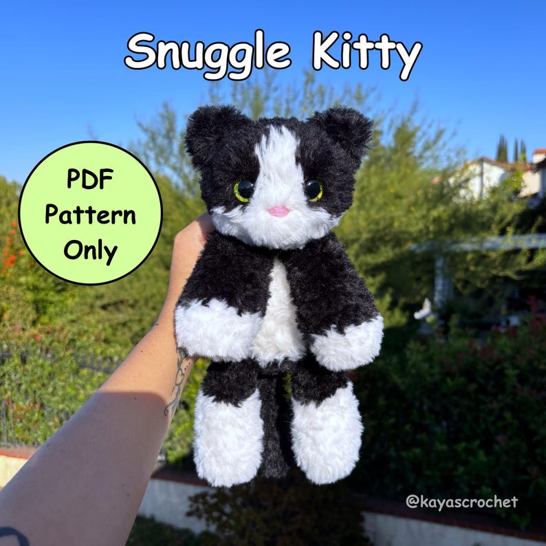 May include: A handmade black and white plush cat toy with the text "Snuggle Kitty". The cat has green eyes and a pink nose. A green circle with the text "PDF Pattern Only" is also visible.