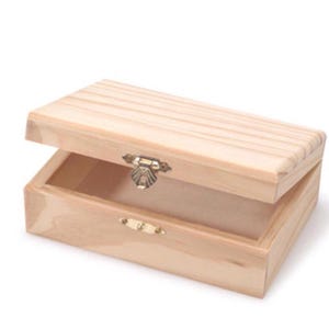 Puede incluir: Una caja de madera natural con tapa abatible y cierre de lat&oacute;n. La caja est&aacute; abierta y vac&iacute;a.