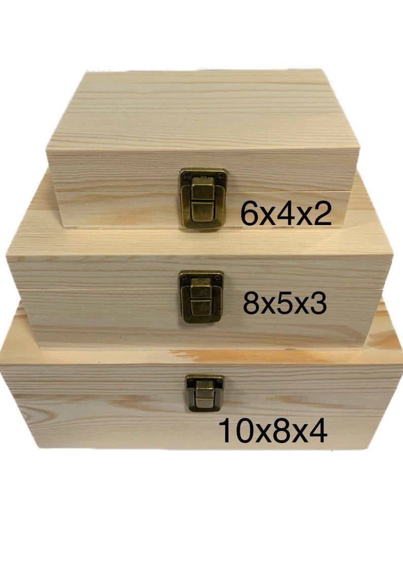 Puede incluir: Tres cajas de madera con cierres de lat&oacute;n, apiladas una encima de la otra. Las cajas son sin terminar y tienen un color de madera natural. Las cajas est&aacute;n etiquetadas con sus dimensiones: 6x4x2, 8x5x3 y 10x8x4.
