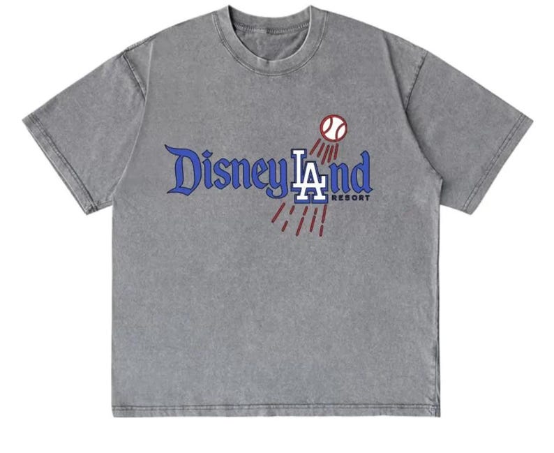 May include: A gray t-shirt with the text "Disneyland LA Resort" in blue and white, with a baseball graphic. The shirt has a vintage, washed look.