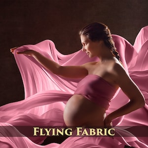 May include: A pregnant person in a pink strapless top poses with a flowing pink fabric draped around them. The fabric is billowing in the air, creating a dramatic effect. The text "FLYING FABRIC" is visible at the bottom of the image.