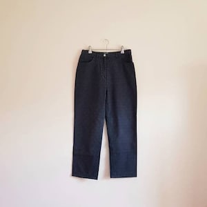 May include: A pair of dark blue, straight-leg trousers with a button fly and belt loops.