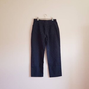 May include: A pair of dark blue denim trousers with a straight leg and a classic five-pocket design.