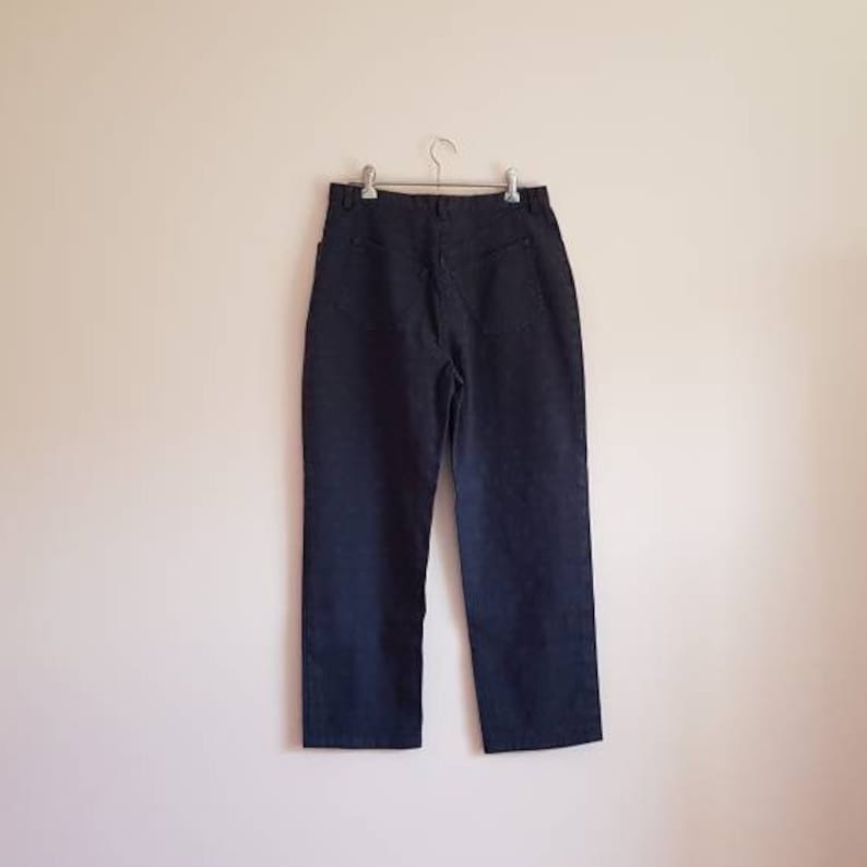 May include: A pair of dark blue denim trousers with a straight leg and a classic five-pocket design.