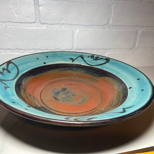 Beautiful piece of signed studio pottery in blues,blacks and oranges