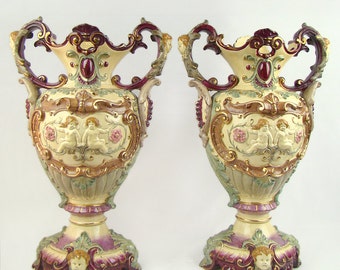 Pair of big Victorian majolica figural urn vases, mythological, polychrome, high relief putto figures and North Wind faces