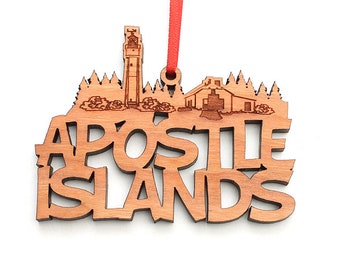 Könnte beinhalten: Holzanhänger mit einer Silhouette der Apostle Islands mit einem Leuchtturm und dem Text "Apostle Islands".