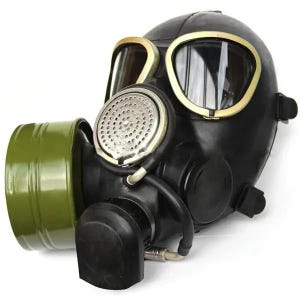Puede incluir: Máscara de gas negra con un filtro verde y lentes con borde dorado. La máscara tiene un filtro circular y una manguera de goma. Diseñada para proteger al usuario de entornos peligrosos.