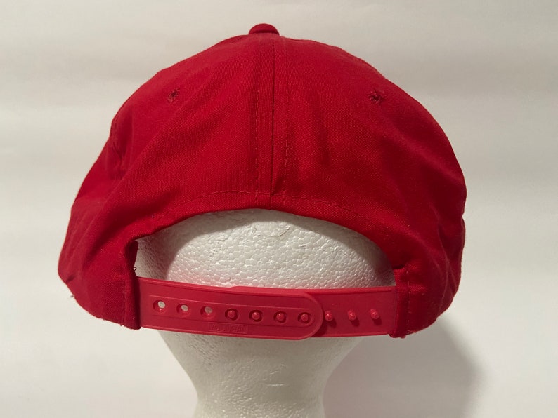 May include: Red baseball cap with a red adjustable strap at the back.