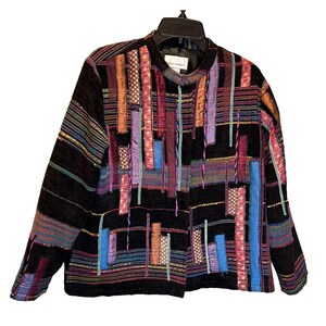 May include: Black jacket with colorful vertical patchwork design. The jacket features a round collar and long sleeves. The patchwork includes shades of purple, blue, red, and gold. The jacket is hanging on a black hanger.