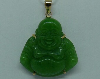May include: A green jade pendant of a smiling Buddha, with gold accents around the edges.