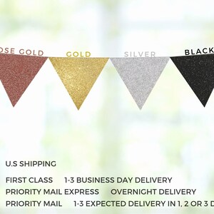 May include: A banner with four triangular flags in rose gold, gold, silver, and black. The flags are made of glitter fabric and are strung together with a thin string.