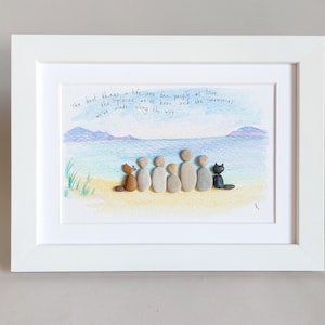 Puede incluir: Una pieza de arte de guijarros enmarcada con una cita sobre las mejores cosas de la vida: "Las mejores cosas de la vida son las personas que amamos, los lugares donde hemos estado y los recuerdos que hemos hecho en el camino." El arte representa a una familia de personas de guijarros y mascotas en una playa.