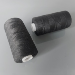 Peut inclure: Deux bobines de fil noir avec des bobines en plastique blanc.