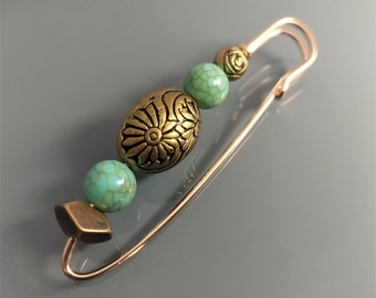 Fancy pin brooch in light gold color with bronze and turquoise beads