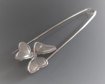 8 cm grote zilverkleurige broche met een bloemmotief.