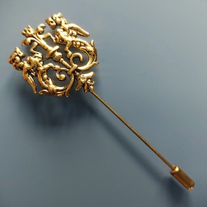 Old gold colored metal shield fibula