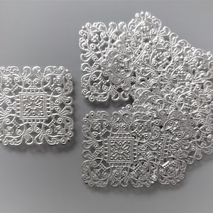 Peut inclure: Ornements en filigrane argentés de différentes formes. Les motifs comprennent des pièces carrées et rectangulaires avec des motifs ajourés complexes. Ces éléments décoratifs sont parfaits pour les projets d'artisanat.
