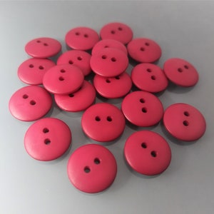 Peut inclure: Un tas de 18 boutons en plastique rouge avec deux trous chacun.