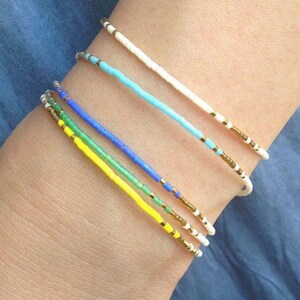 yellow, blue, gold , gren , white beaded seed bead bracelets on arm, Everyday bracelet tiny gold bracelet gold bead bracelet Every day Jewelry