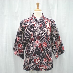 May include: A dark navy blue kimono-style jacket with a repeating pattern of red, white, and black Japanese-style graphics. The jacket has short sleeves and a V-neck collar, displayed on a mannequin.