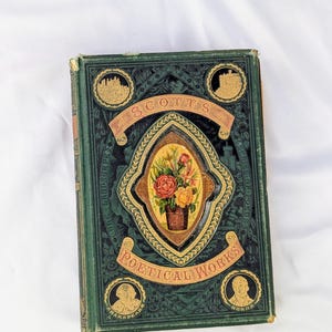 May include: A vintage hardcover book titled Scott's Poetical Works with a dark green cover. The front features an ornate gold-embossed frame surrounding a central oval illustration of a floral bouquet, with four circular gold portraits and scenes.