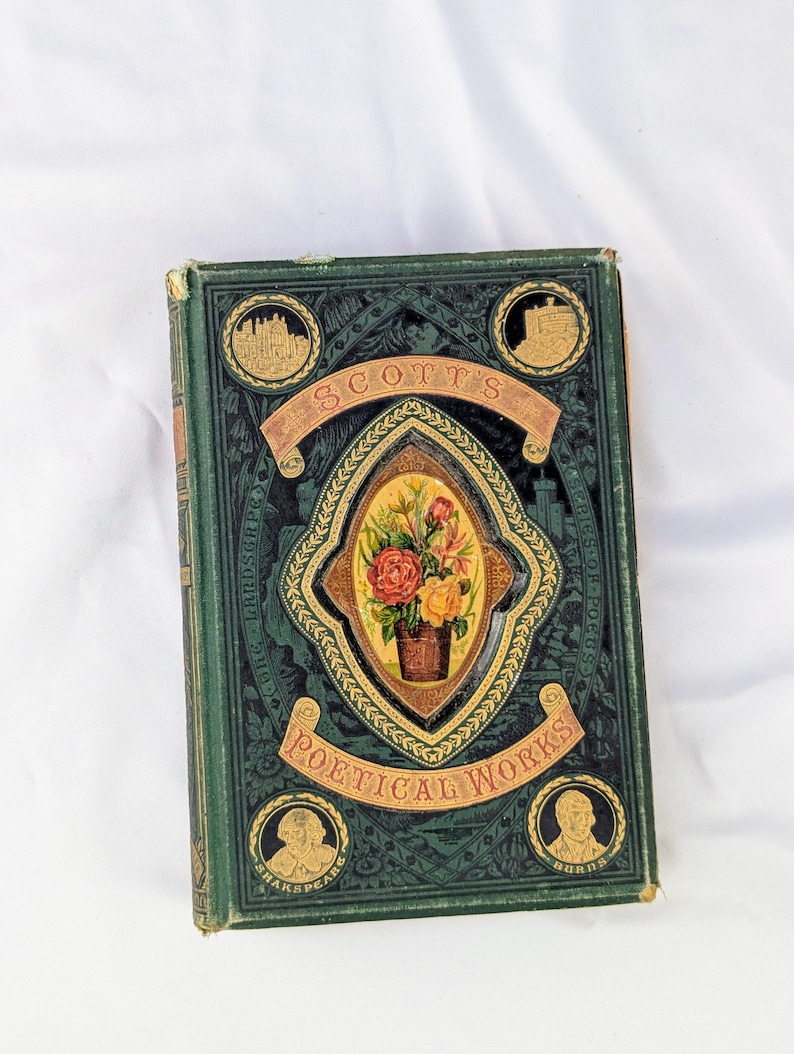 May include: A vintage hardcover book titled Scott's Poetical Works with a dark green cover. The front features an ornate gold-embossed frame surrounding a central oval illustration of a floral bouquet, with four circular gold portraits and scenes.